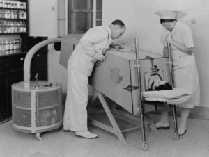 A polio patient lies in an iron lung in March 1940. When polio weakened muscles used in breathing, the device assisted with respiration.